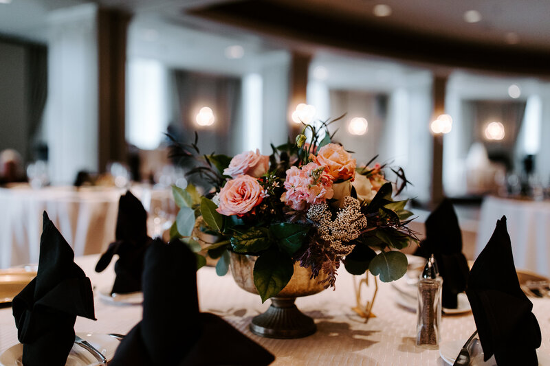 Table with black napkins and a dark floral centerpiece