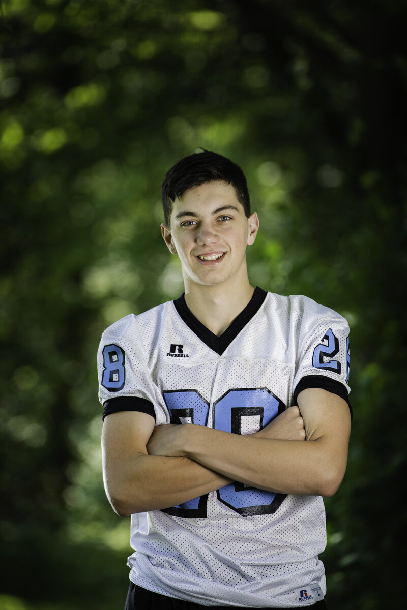teenage boy wearing a football jersey on picture day