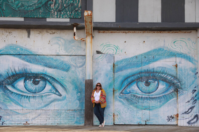 Kim standing outside next to a mural