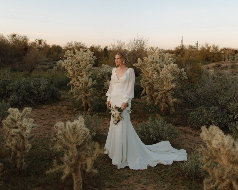 a bride is standing outside looking toward the sun after it has already set