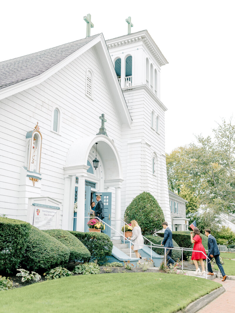 Wedding guests walking into a white steepled church in Edgartown, Martha's Vineyard