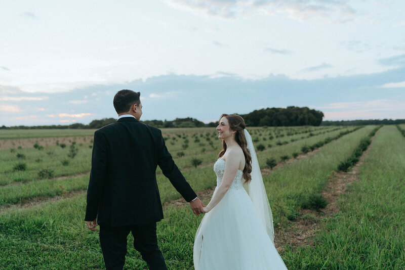 bride and groom in a field, shot by elsie goodman photography