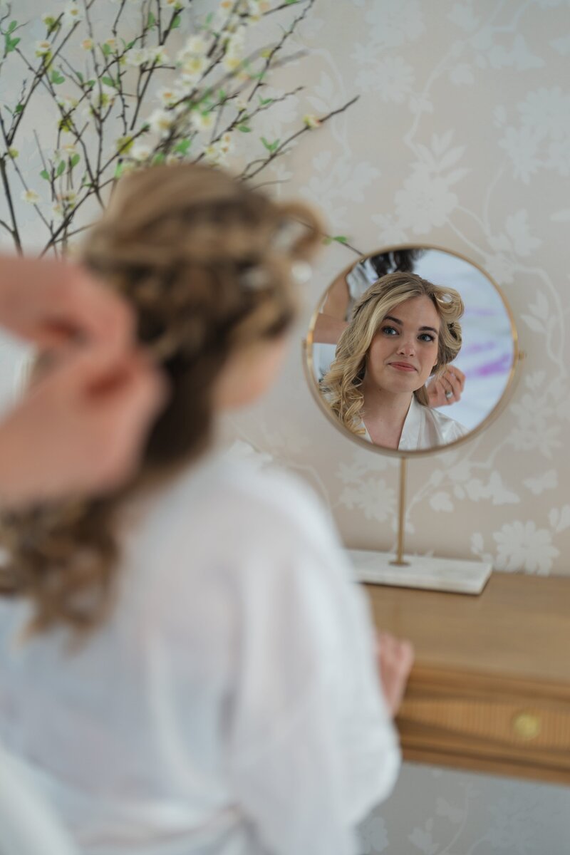 bride getting hair done at wedding