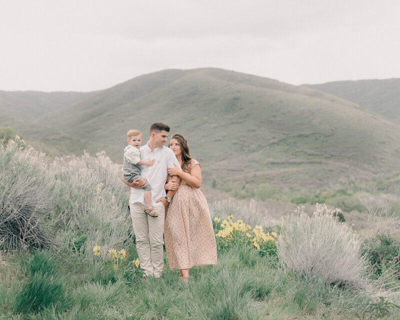 Mother-to-be in flowing dress cradling belly at sunset in the Utah mountains. CAPTURED BY Newborn Photography Salt Lake City, Newborn Photographer Riverton, Maternity Photographer Salt Lake City.