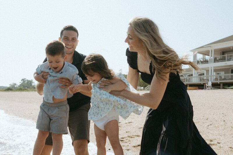 couple holding their kids above water during family photos at the beach by NYC family photographer Elsie Goodman