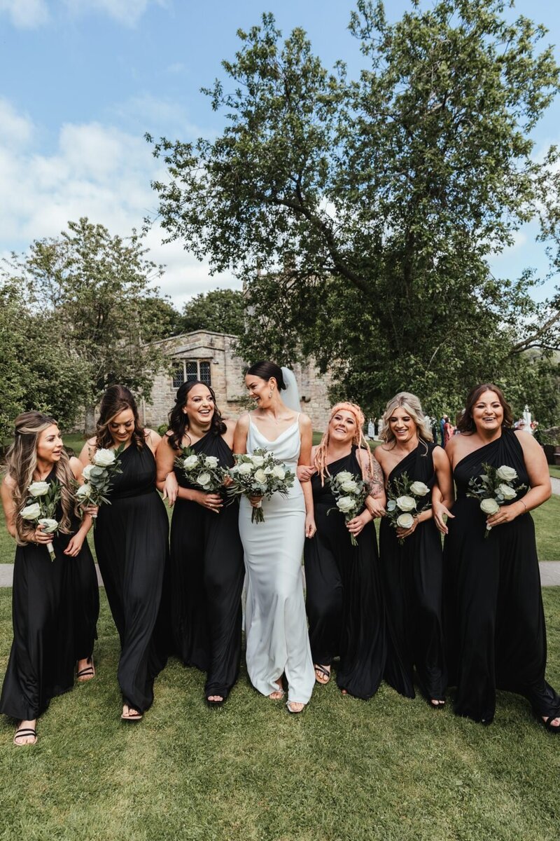Bride and her bridesmaids in black dresses at The Priesthouse wedding venue