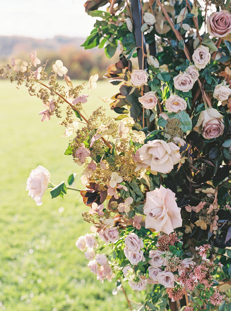 Romantic floral arch with pastel blooms, showcasing design artistry from a Seattle Wedding Albums & Estate Wedding Photography expert.
