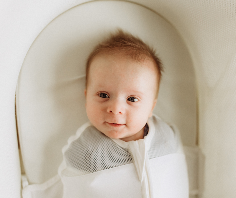 woman holding a smiling baby up in the air