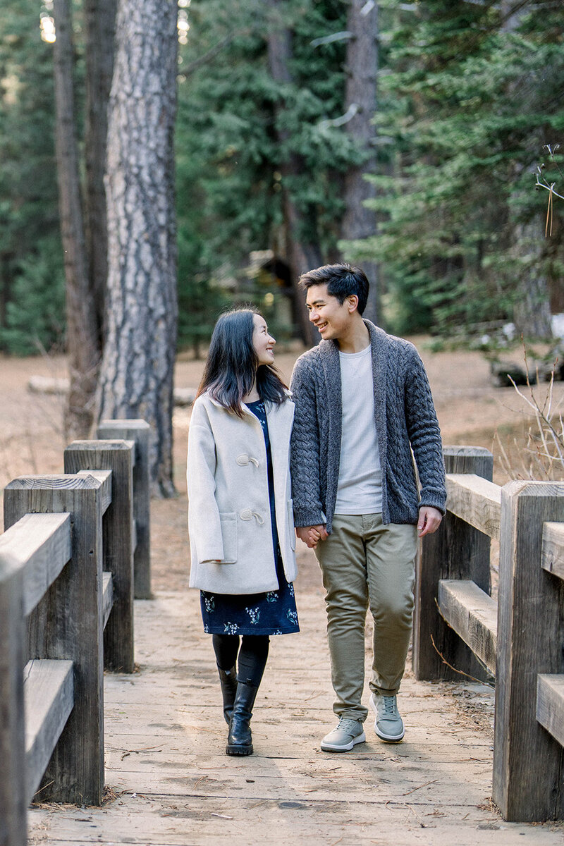 A couple enjoys a rustic engagement session amidst the towering trees of Yosemite National Park, California, captured by Tiffany Longeway Photography.