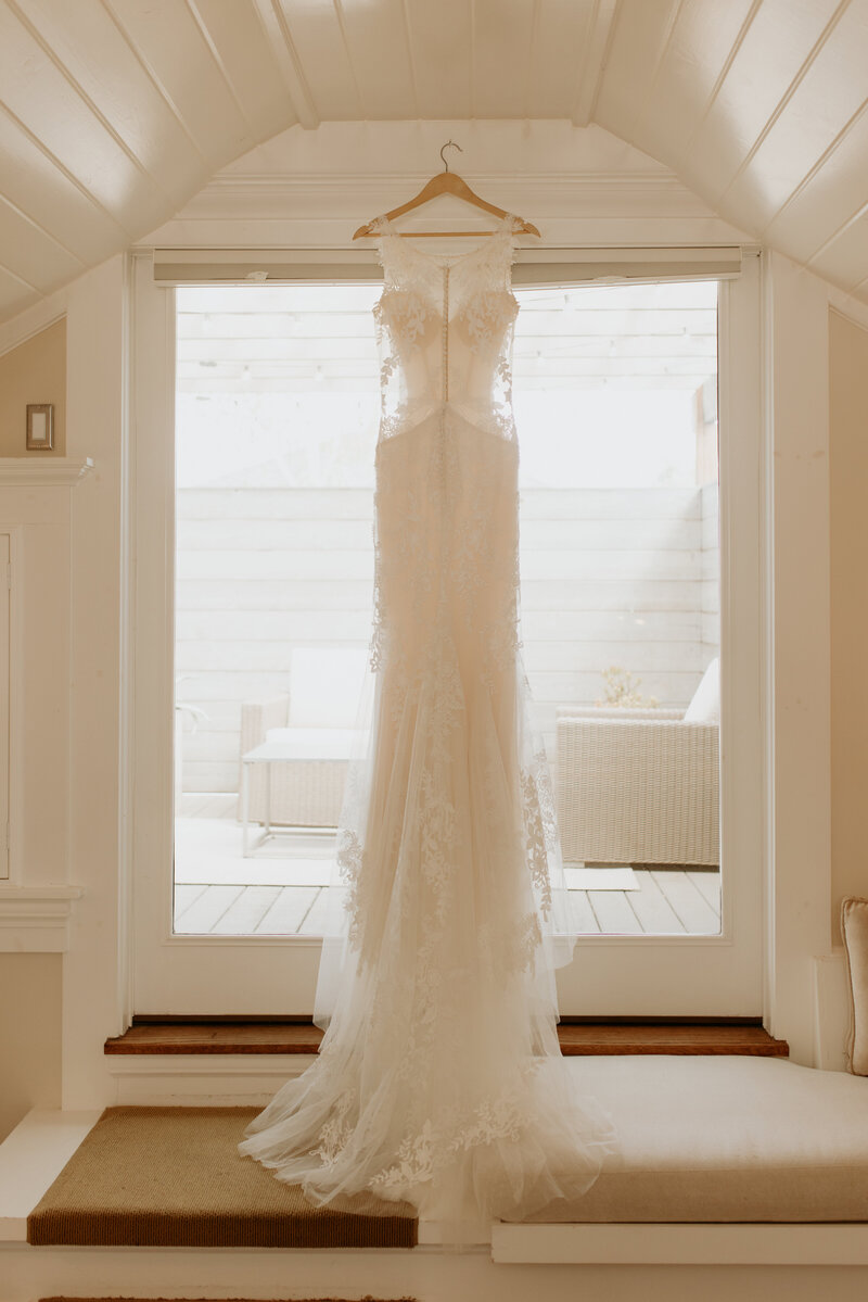 A wedding dress hanging in a doorway