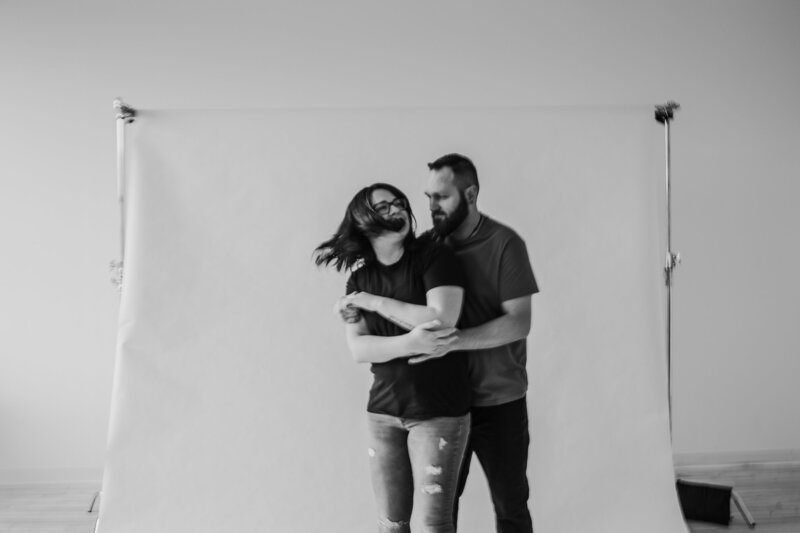 black and white image of man and woman dancing in front of a studio backdrop