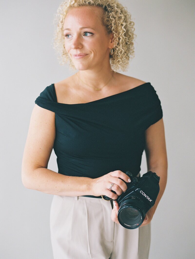 One of the premier chicago wedding photographers Allison Francois posing with camera