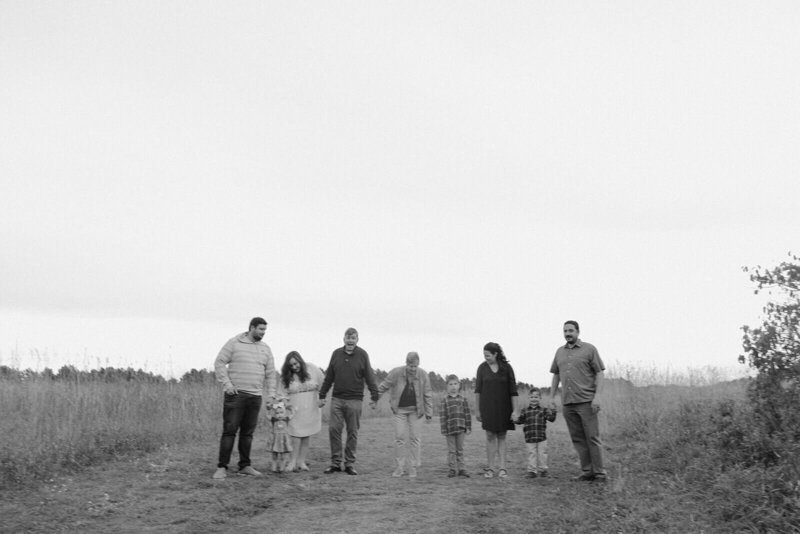 Family holds hands in Minnesota meadow