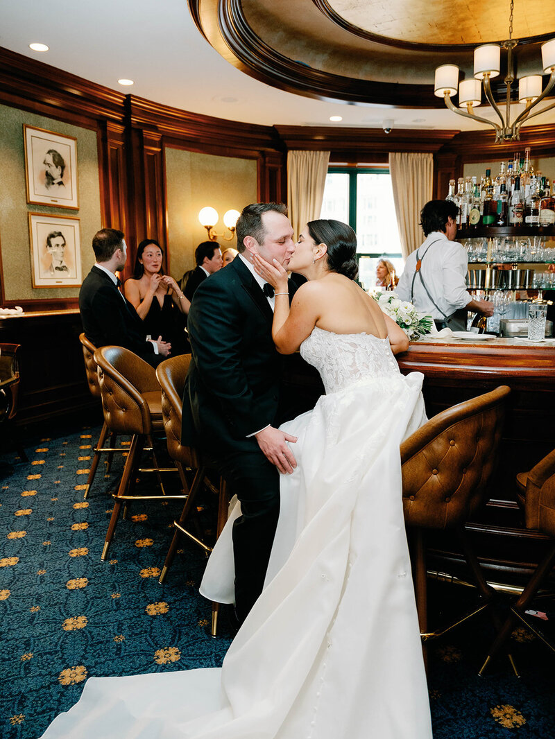 Bride and groom share a kiss at round robin bar at the Willard Intercontinental 