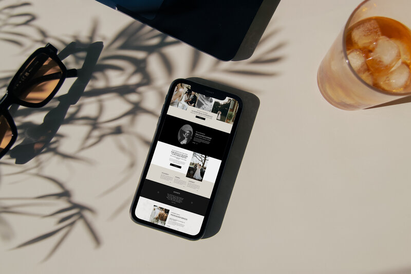 A poster depicting an elopement photographer website homepage resting on a deep sienna colored leather couch