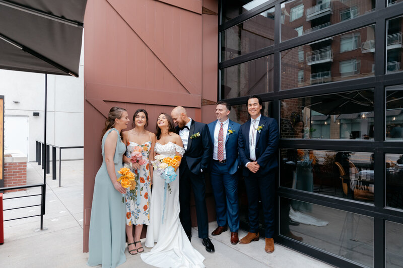 Wedding party standing in front of industrial modern doors of Woodie Fisher during Denver wedding photos