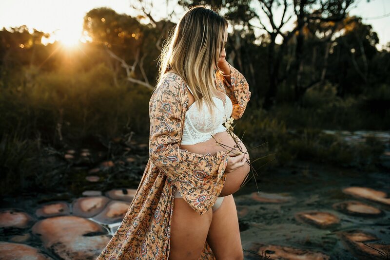 Pregnant woman in floral robe walking in pretty light