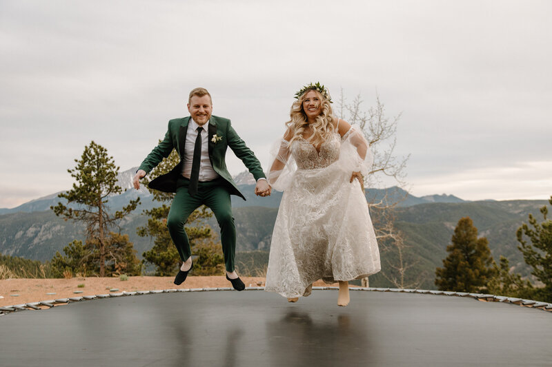 couple jumping on trampoline after eloping in colorado