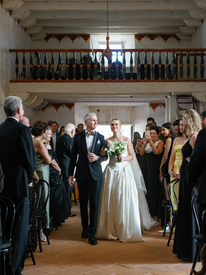 groom in tuxedo kissing bride