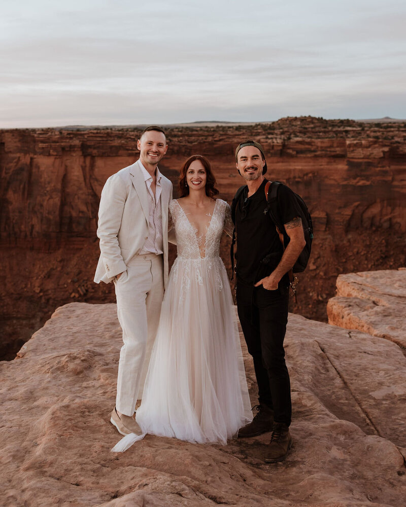 photographer smiling with wedding couple