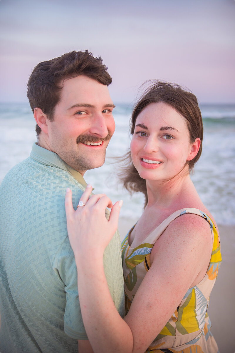 newly engaged couple looking over shoulder