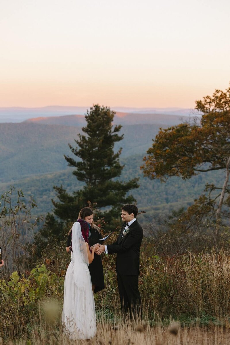 A bride and groom hold hands while saying their vows to one another at the their elopement ceremony at Jewell Hollow in Shenandoah National Park