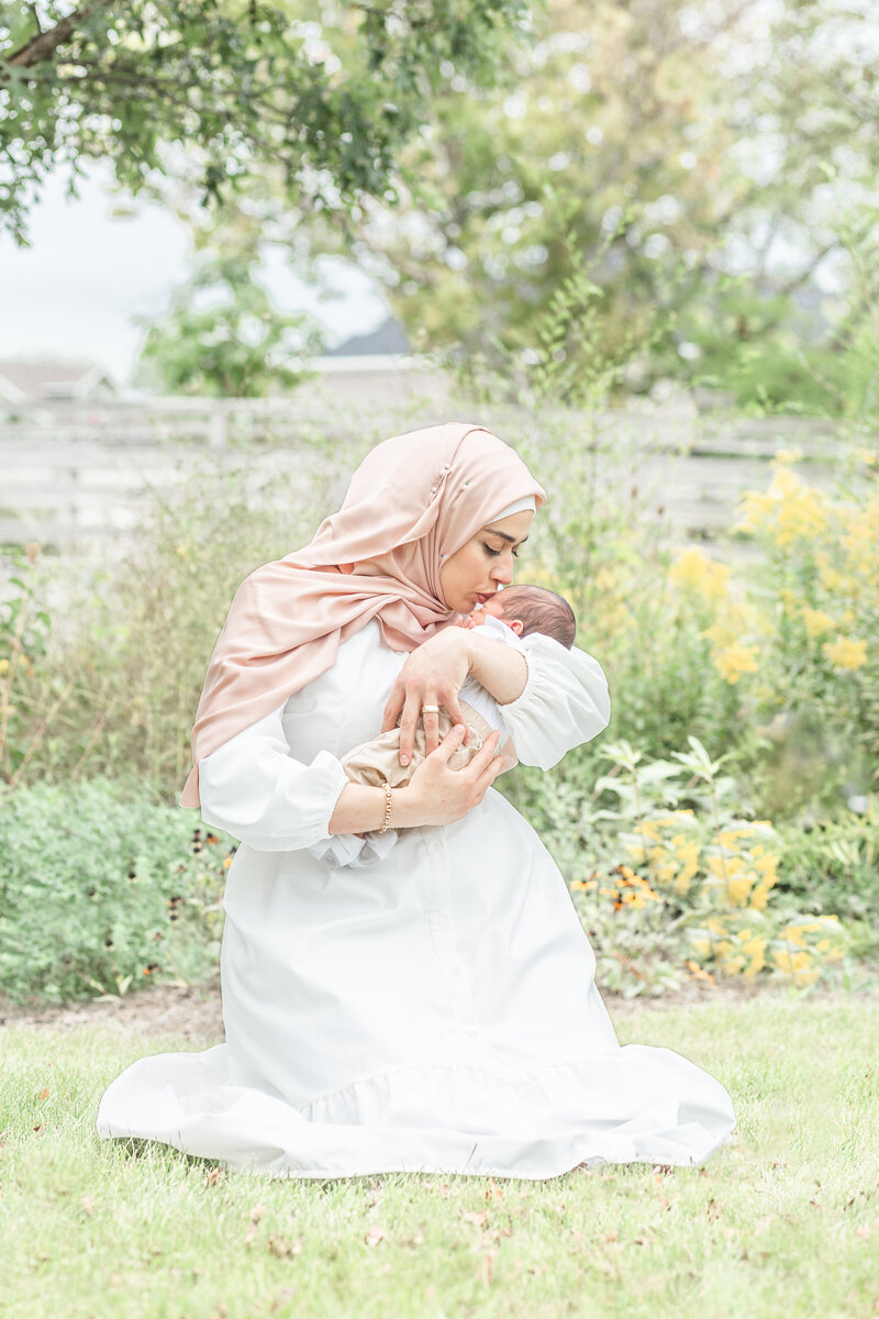 New Mom posing with baby in Livonia, Michigan, outdoor newborn photographer at Nankin Mills