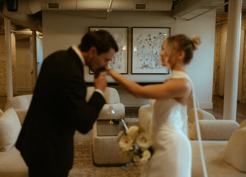 groom kissing bride's hand