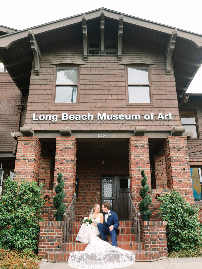 calm romantic wedding photography of bride and groom sitting in front of long beach museum of art wedding venue