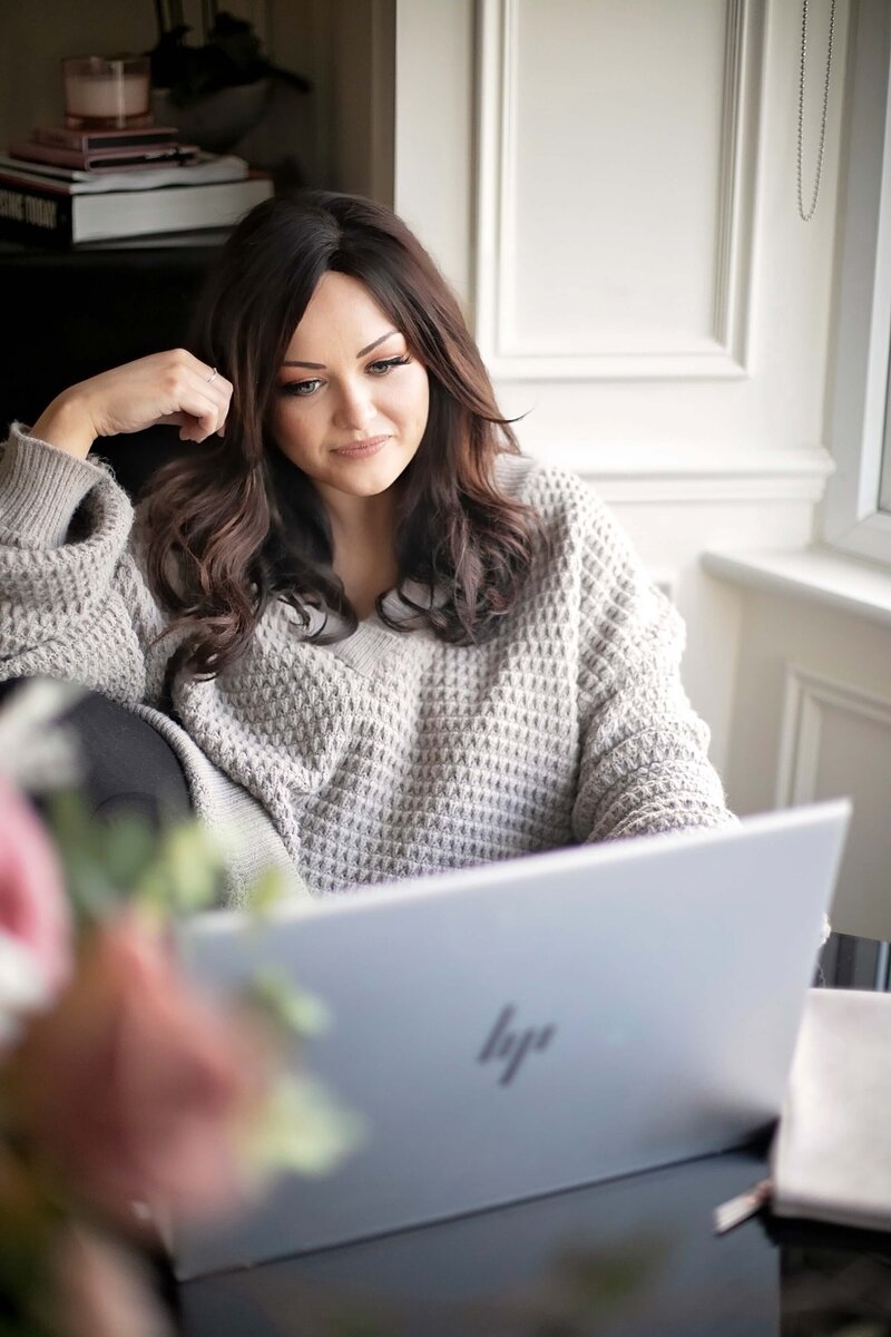 Two female business owners working on laptop and making notes