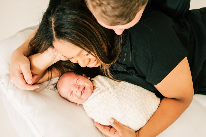 Springfield Mo newborn photography of parent laying with smiling newborn