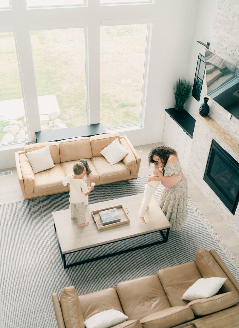 Soft and intimate maternity session in Riverton, Utah, with a mother and her toddlers sharing sweet moments together—photographed in natural light by a Riverton family photographer.