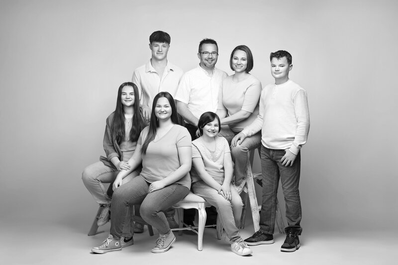 collection of family portraits hanging on a wall in a living room