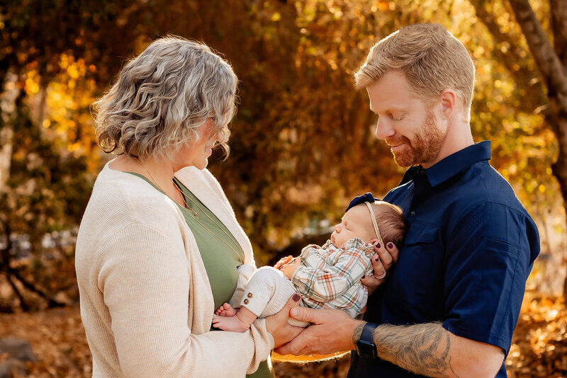 Newborn photographer, a baby sleeps dressed as a teddy bear holding a bear