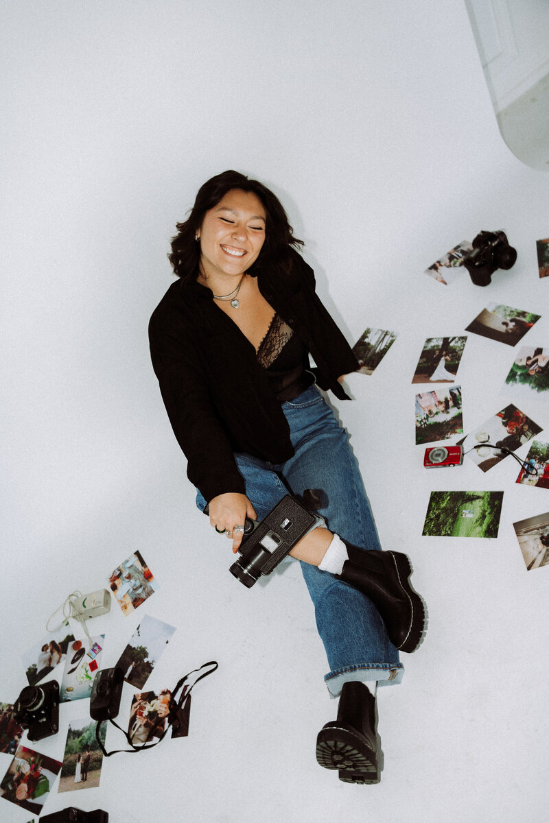 young super 8 film photographer, destination wedding photographer sitting next to multiple wedding photographs