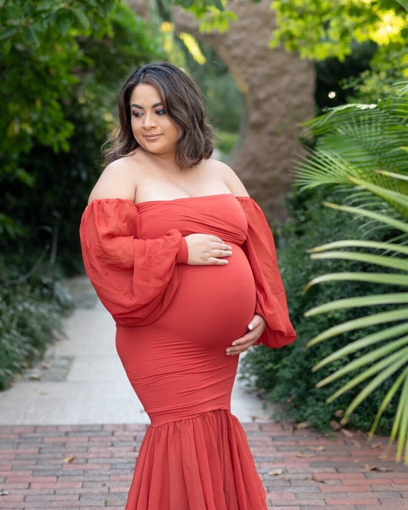 Pregnant woman holding belly in maternity outdoor photoshoot in Maryland