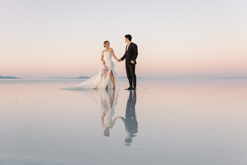 Utah Wedding Photographers capture bride and groom dancing on the Salt Flats after mountain elopement