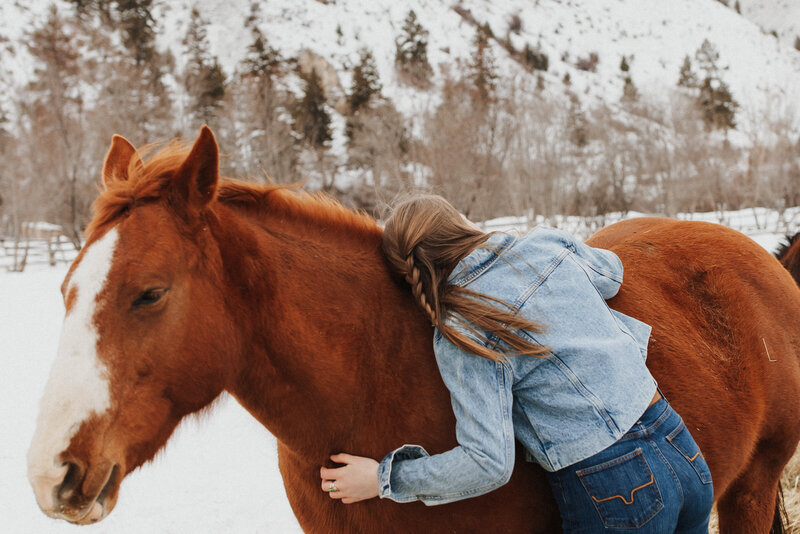 A cowgirl and her horse in the snow