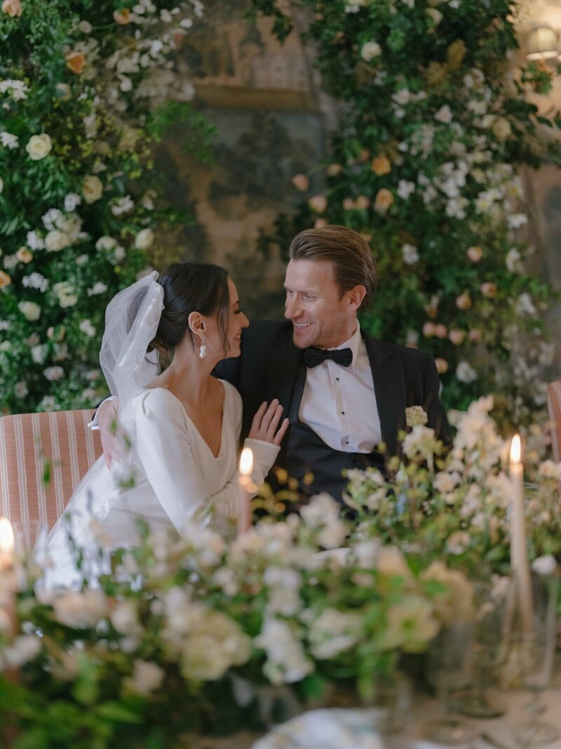 Bride and Groom at wedding table surrounded by flowers
