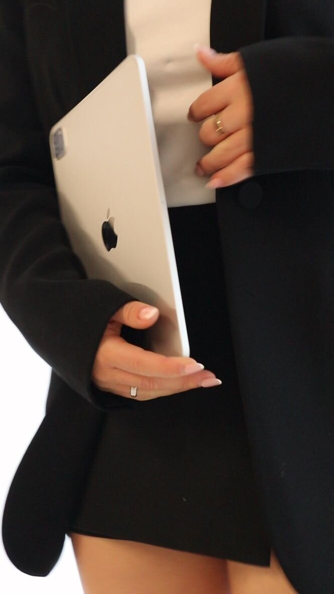 Event planner in sleek black blazer holding a laptop — ready to bring style and strategy to the next big celebration.