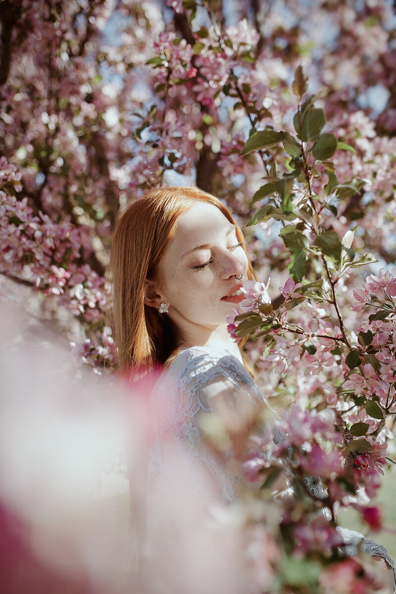 Woman with red hair posing in flowers