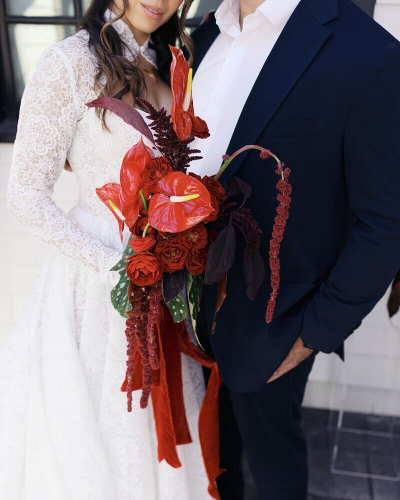 bride and groom holding red bouquet taken by Nashville wedding photographer Sammy Mckenzie