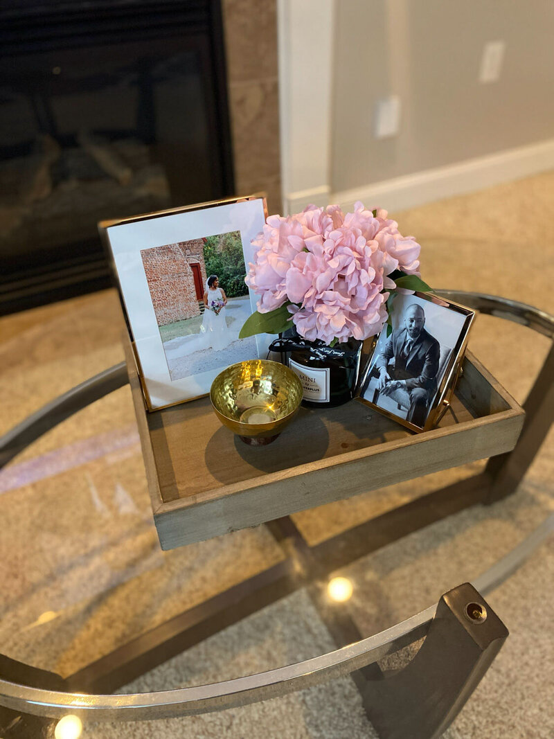 coffee table decor with wedding photos and pink flowers with brass bowl