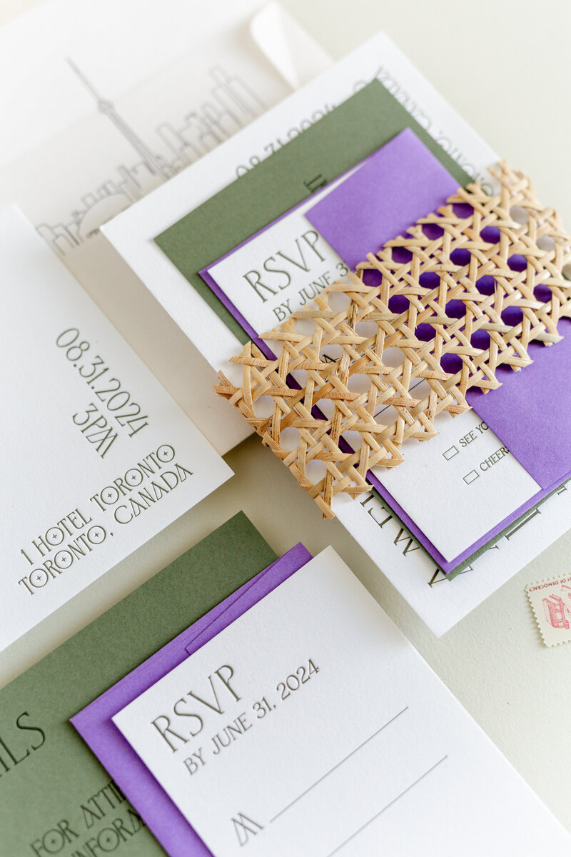 Modern, textural, and clean wedding invitation suite featuring layered RSVP and detail cards in green and purple with a woven rattan wrap, designed by Grey Cove Designs for a Toronto, Canada celebration.