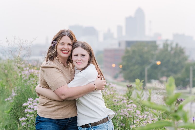 a mom hugging her teenage daughter