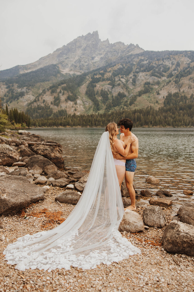 bride and groom kissing in lake