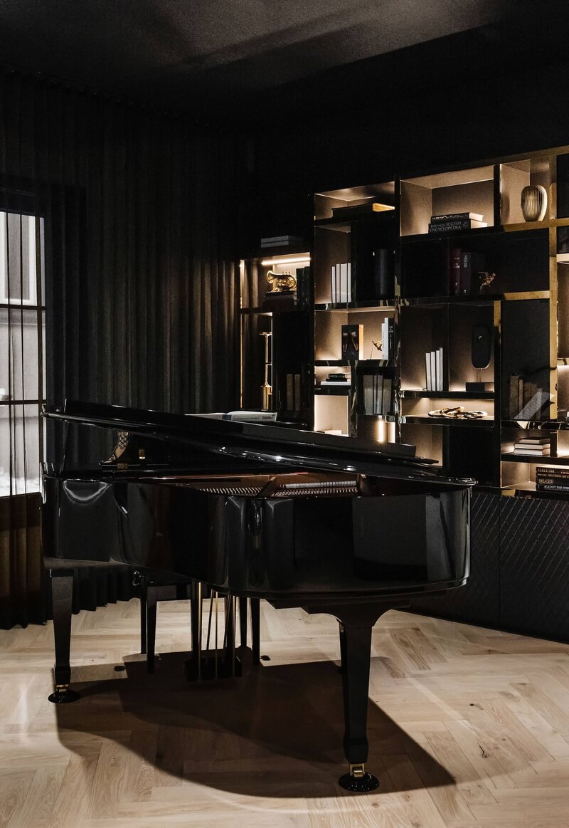 A grand piano paired with a beautiful built in featuring smoky glass and gold accents. 