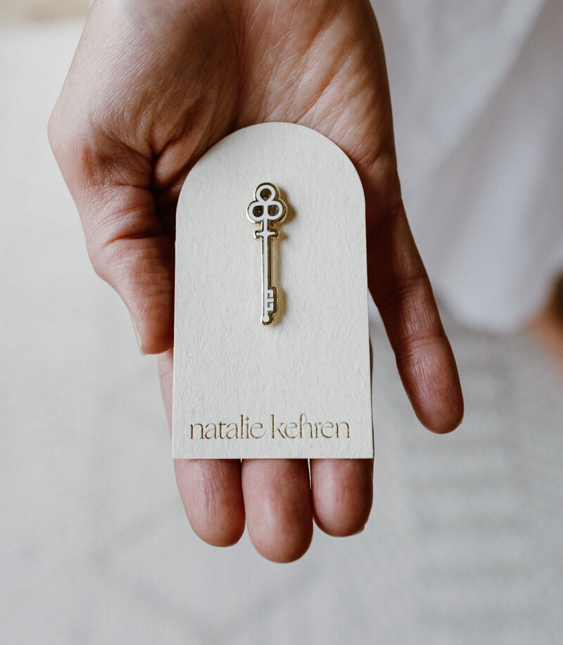 Custom branding and product packaging design for a women-owned wellness and spirituality business, featuring a key pin on embossed card by Moonstone Creative.