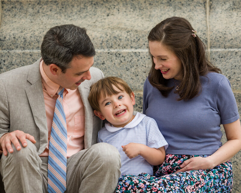 A young boy in bright spring colors grinning mischievously at the camera in Valley Forge.