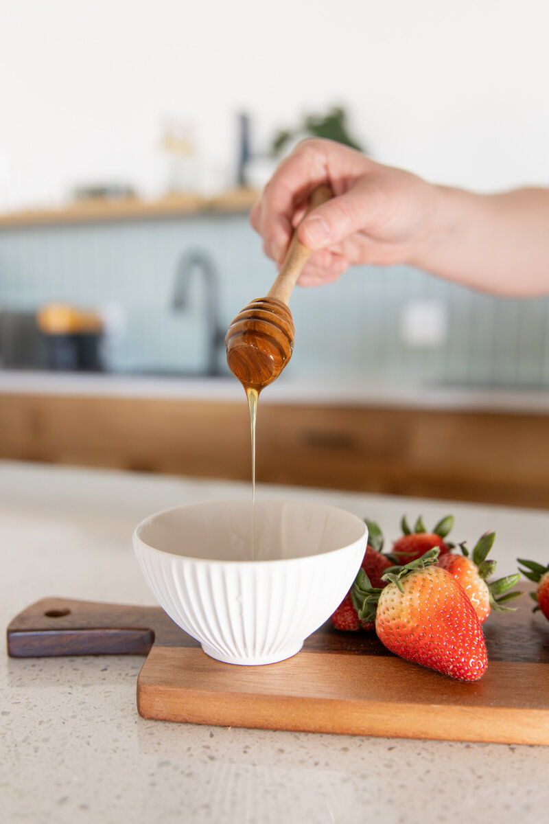 up close shot of honey dripping down into bowl for a brand shoot